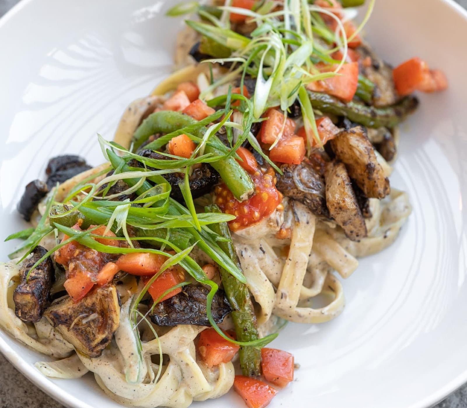 Creamy fettuccine with charred mushrooms, snap peas, and tomato